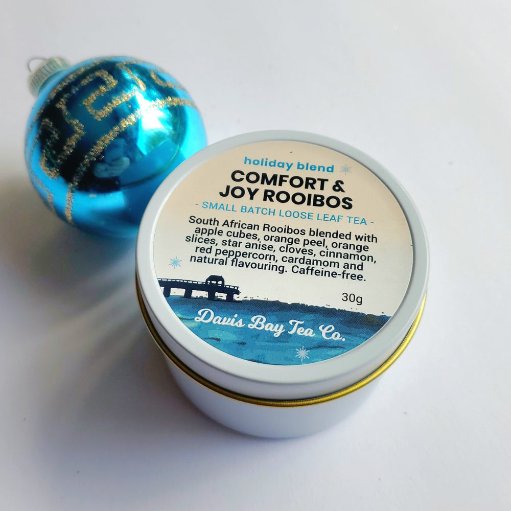 
                  
                    Tin of Davis Bay Tea Co. Comfort & Joy Rooibos tea with a blue ornament on a white background
                  
                