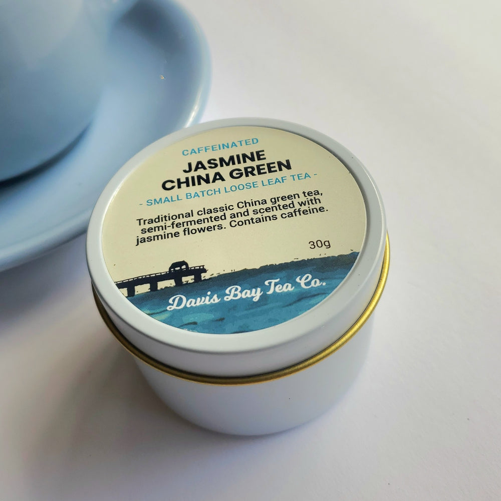 
                  
                    Davis Bay Tea blend of Jasmine China green tea in white tin beside a light blue teacup on a white background

                  
                