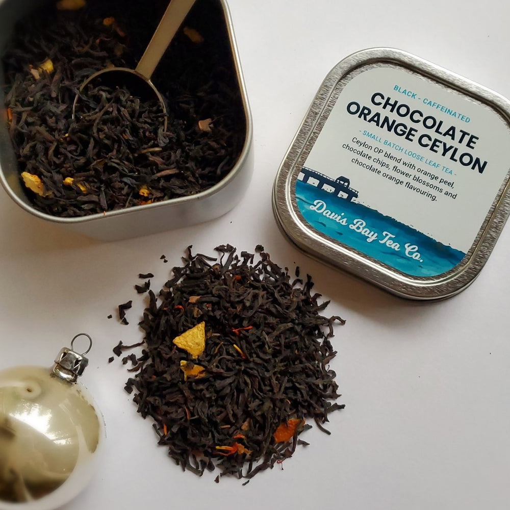 
                  
                    open tin of Chocolate Orange Ceylon tea with tea scoop in tin and pile of tea on display
                  
                