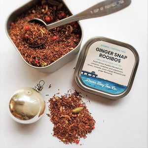 
                  
                    open tin of Ginger Snap Rooibos tea with scoop and pile of tea on display
                  
                