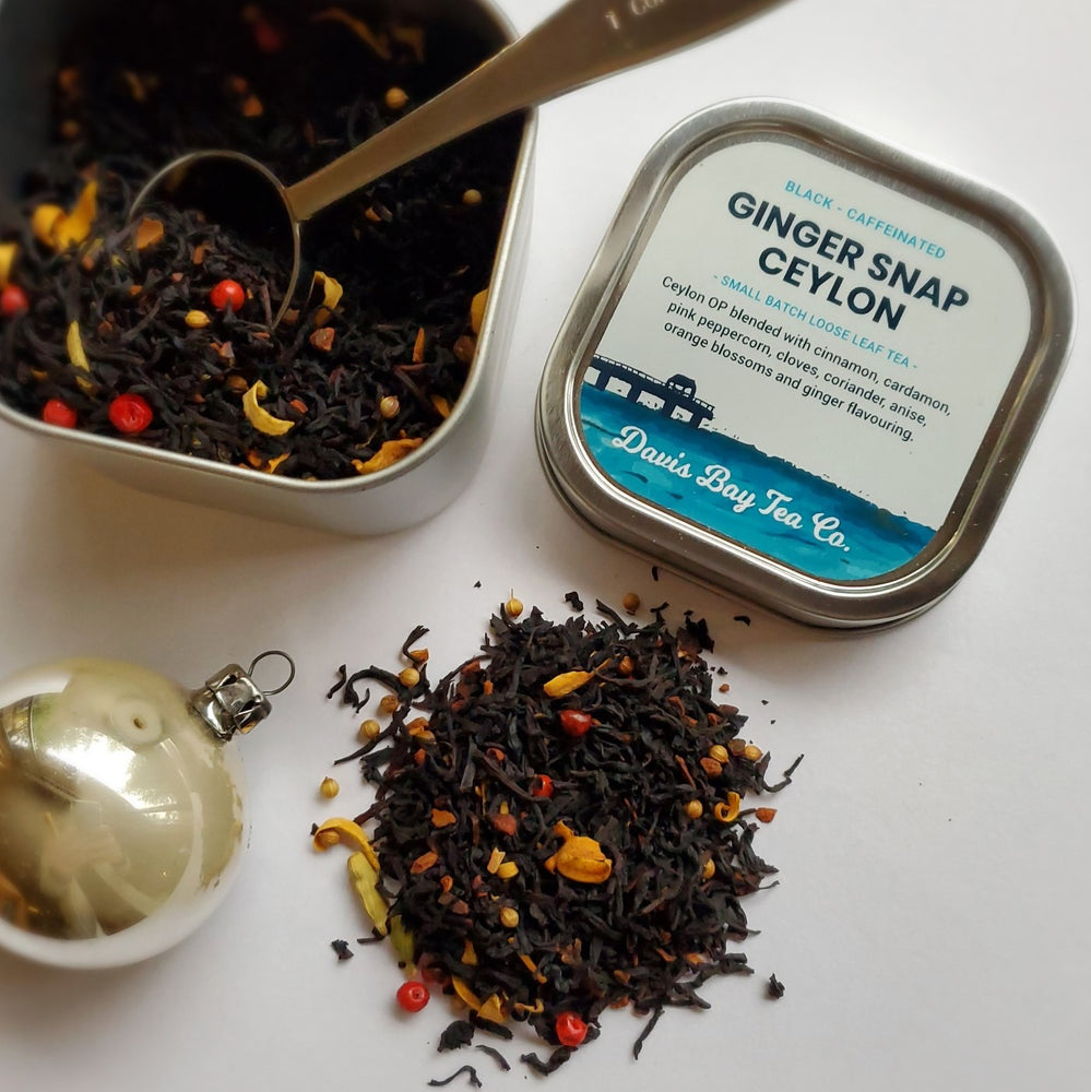 
                  
                    open tin of Ginger Snap Ceylon black tea with scoop and pile of tea 
                  
                
