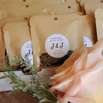 Wedding favours  with tea. Brown kraft paper compostable packages with window and custom monogram stickers 